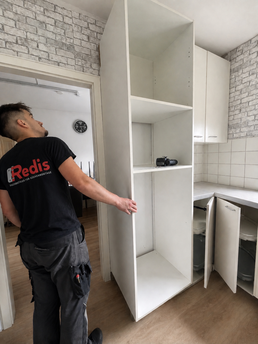Monteur beim Küchenaufbau – Oberschrank wird exakt ausgerichtet
